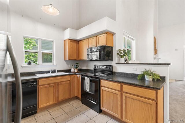 5444 Zephyr St Unit 203, Arvada, CO 80002 - kitchen featuring black appliances, a sink, a high ceiling, dark countertops, and light tile patterned floors