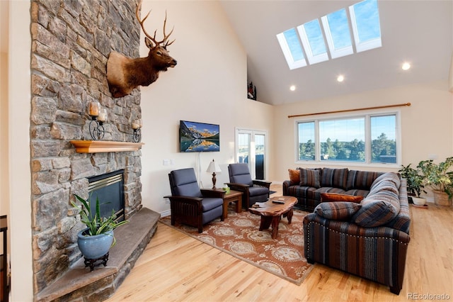 34274 Wolf Creek Trl, Kiowa, CO 80117 - living area with a skylight, wood finished floors, a fireplace, high vaulted ceiling, and recessed lighting
