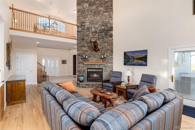 34274 Wolf Creek Trl, Kiowa, CO 80117 - living room featuring a high ceiling, light wood-type flooring, a fireplace, and baseboards