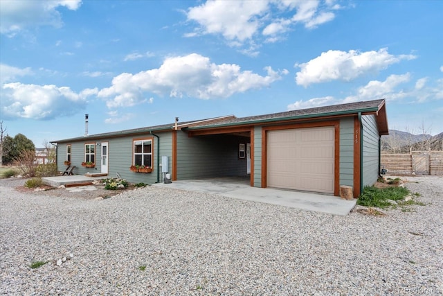 view of front of house featuring fence, driveway, and a carport
