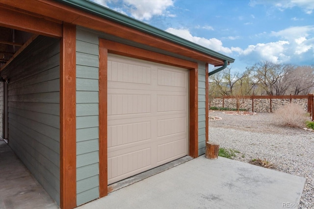 garage featuring fence and driveway