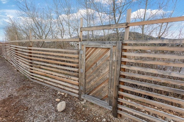 view of outbuilding featuring fence and a gate