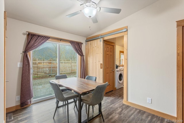 dining room with baseboards, vaulted ceiling, washer / clothes dryer, and wood finished floors