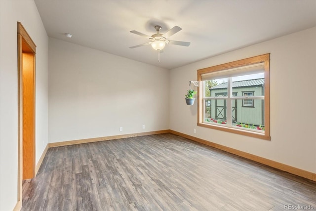 spare room featuring baseboards, a ceiling fan, and wood finished floors