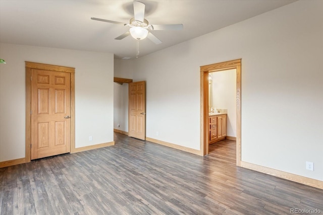 unfurnished bedroom featuring a ceiling fan, baseboards, wood finished floors, and ensuite bathroom