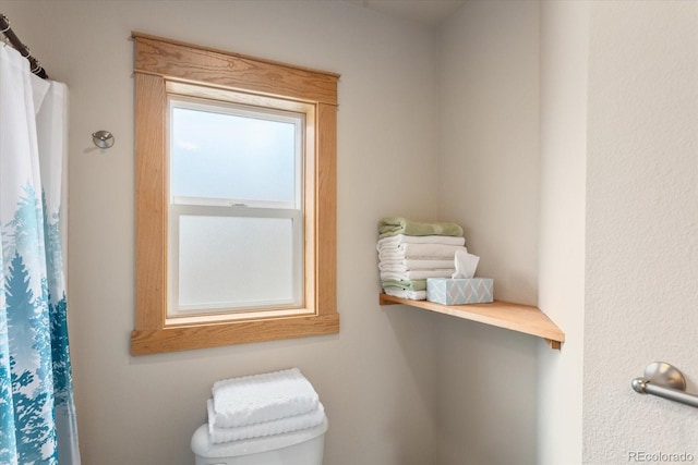 full bathroom with toilet and a shower with shower curtain