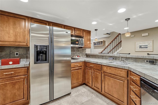 kitchen with appliances with stainless steel finishes, decorative light fixtures, light tile patterned floors, decorative backsplash, and sink