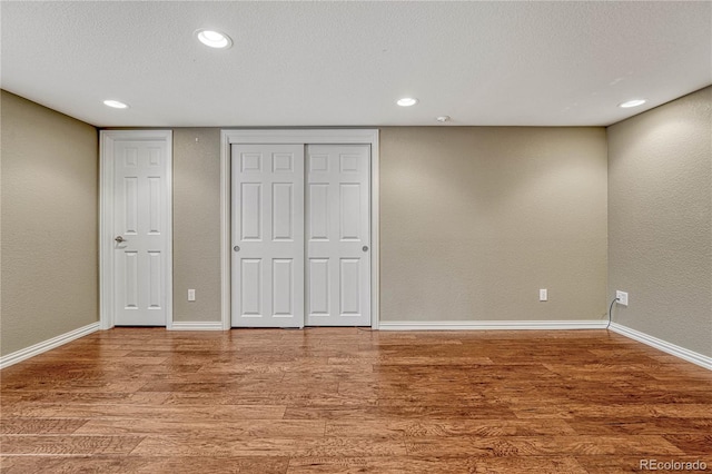 unfurnished bedroom featuring hardwood / wood-style floors and a textured ceiling