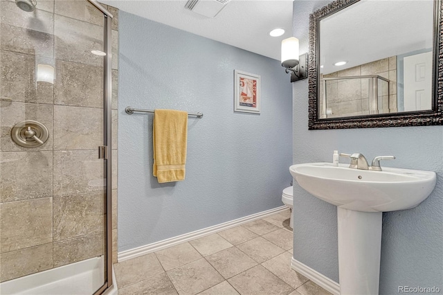 bathroom with tile patterned floors, toilet, and an enclosed shower