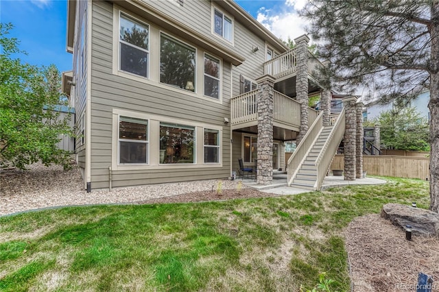 back of property with a yard and a patio area