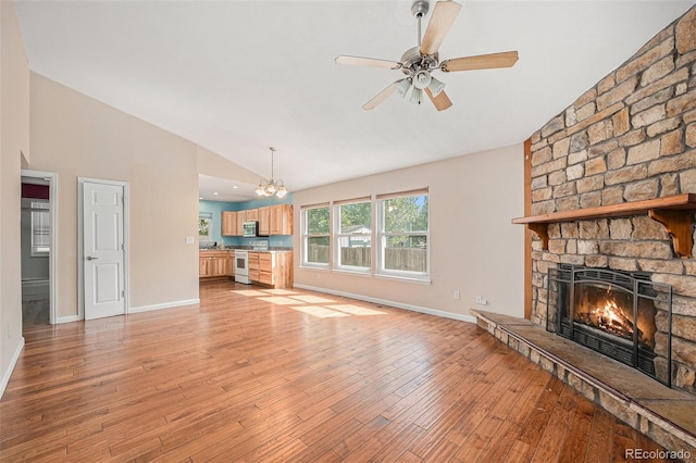 7834 S Windermere Cir, Littleton, CO 80120 - unfurnished living room featuring a stone fireplace, a chandelier, light wood-style flooring, ceiling fan, and high vaulted ceiling