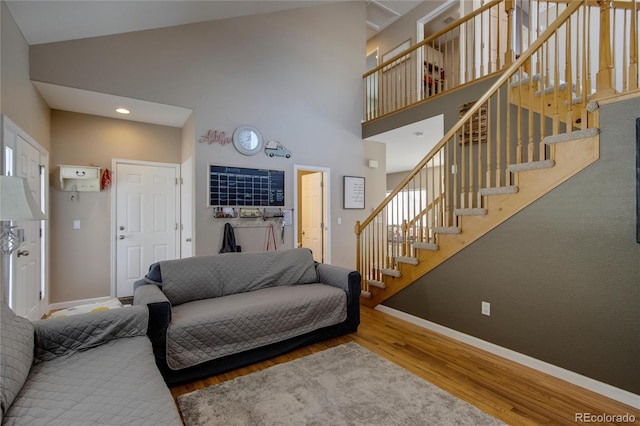 living room with hardwood / wood-style flooring and high vaulted ceiling