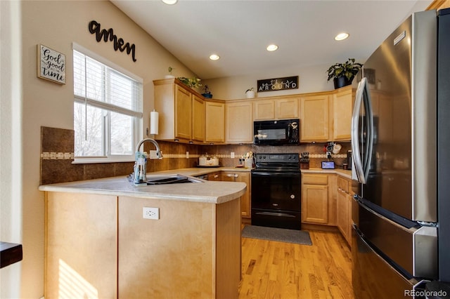 kitchen featuring light brown cabinetry, sink, black appliances, kitchen peninsula, and backsplash