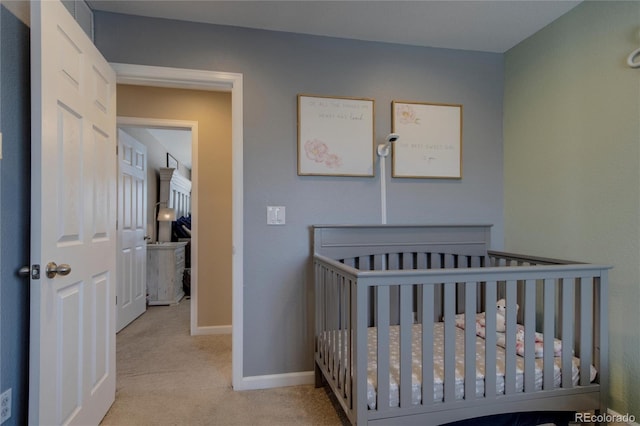 carpeted bedroom featuring a nursery area