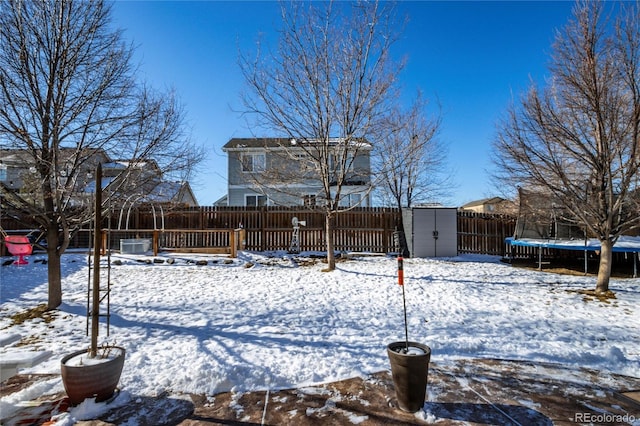 snow covered house with a trampoline and a storage shed