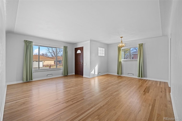 interior space featuring light hardwood / wood-style floors, an inviting chandelier, and plenty of natural light