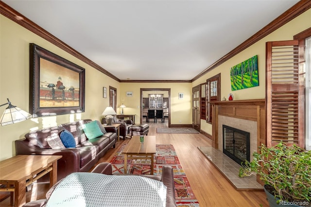 living room with ornamental molding, a fireplace, and light hardwood / wood-style flooring