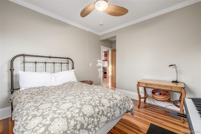 bedroom featuring ceiling fan, wood-type flooring, and ornamental molding