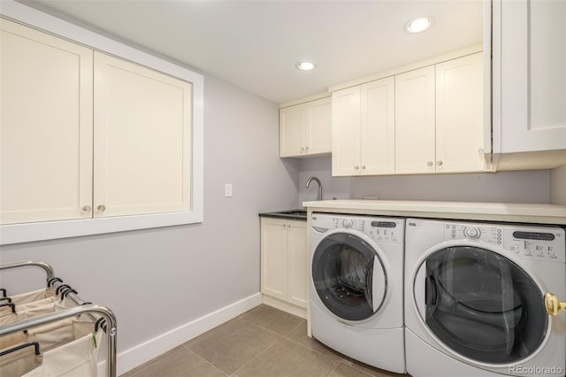 clothes washing area featuring tile patterned floors, cabinets, sink, and washer and dryer