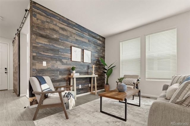 4343 S Nepal Ct, Centennial, CO 80015 - living area with an accent wall, a barn door, light wood-type flooring, and wood walls