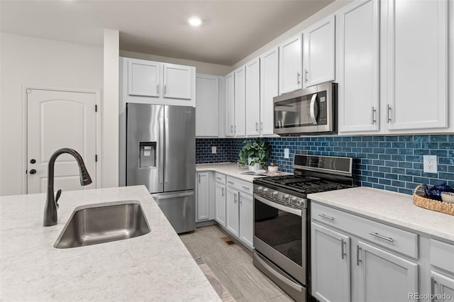 4343 S Nepal Ct, Centennial, CO 80015 - kitchen with appliances with stainless steel finishes, light wood-style floors, decorative backsplash, recessed lighting, and white cabinets