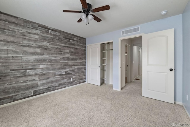4343 S Nepal Ct, Centennial, CO 80015 - unfurnished bedroom featuring an accent wall, carpet floors, wood walls, a closet, and a ceiling fan