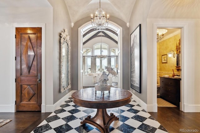 entrance foyer with a chandelier, lofted ceiling, and baseboards