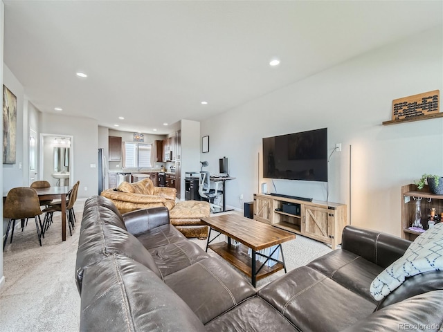 living room with recessed lighting, light colored carpet, and baseboards