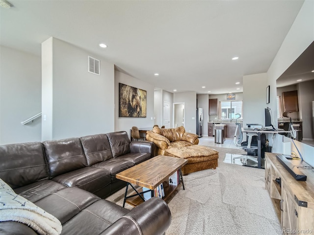 living area with light carpet, visible vents, and recessed lighting