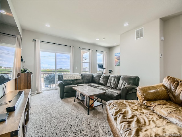 living area featuring carpet floors, recessed lighting, and visible vents