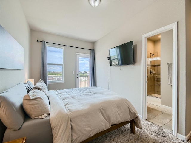 bedroom featuring access to exterior, baseboards, ensuite bath, and light tile patterned floors