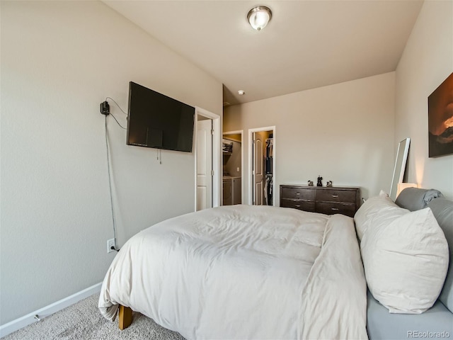 carpeted bedroom featuring a closet, a spacious closet, and baseboards