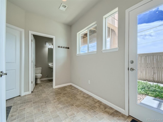 doorway to outside featuring baseboards and visible vents