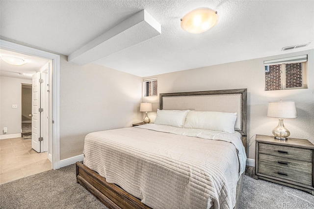 bedroom featuring baseboards, visible vents, a textured ceiling, and carpet flooring