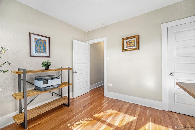 office space featuring light wood-type flooring and baseboards