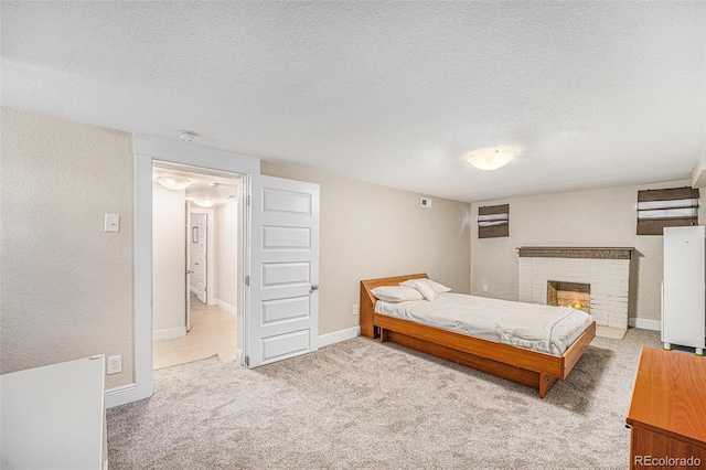 carpeted bedroom with a fireplace, a textured ceiling, and baseboards