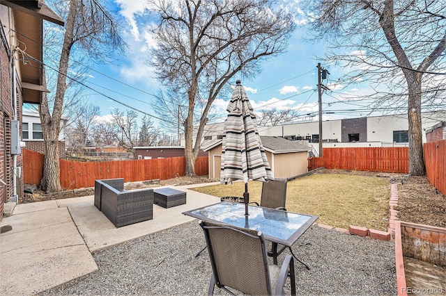 view of patio with outdoor dining space, a fenced backyard, an outdoor structure, and an outdoor hangout area