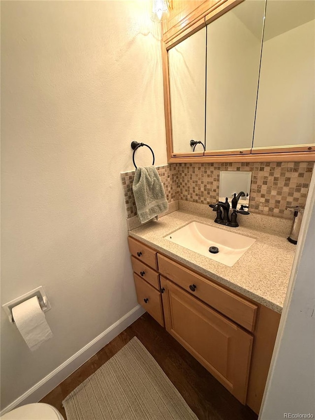 3262 S Salida Way, Aurora, CO 80013 - half bathroom with vanity, tasteful backsplash, and wood finished floors