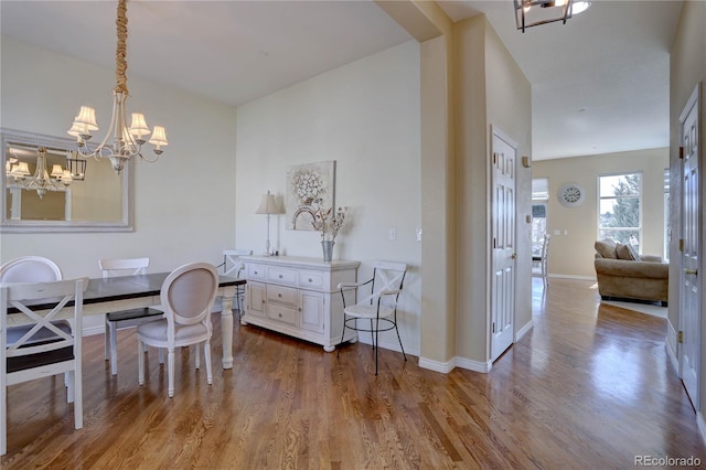 dining area with a notable chandelier, baseboards, and wood finished floors