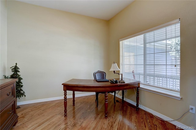 home office with light wood-type flooring and baseboards