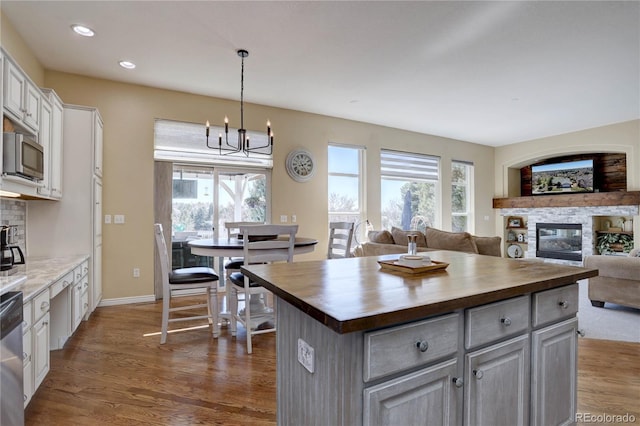 kitchen featuring wooden counters, dark wood finished floors, appliances with stainless steel finishes, and a healthy amount of sunlight