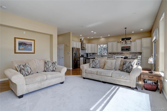 living area featuring recessed lighting, baseboards, and light colored carpet