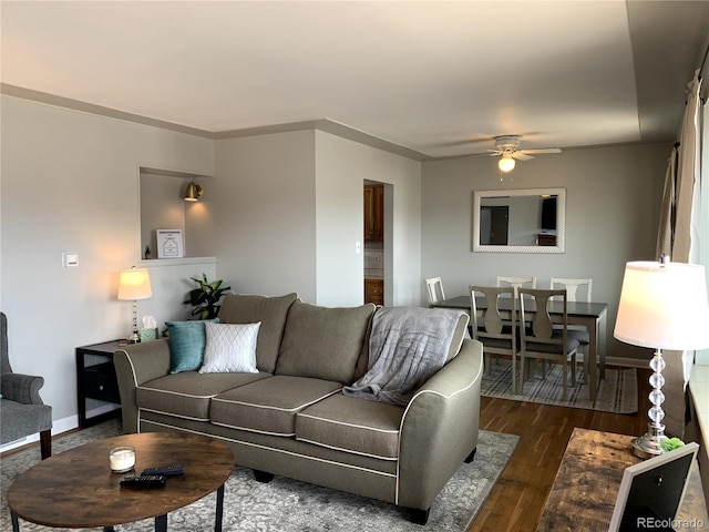 living room featuring ceiling fan, crown molding, and dark wood-type flooring