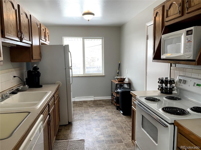 kitchen with white appliances, sink, and tasteful backsplash