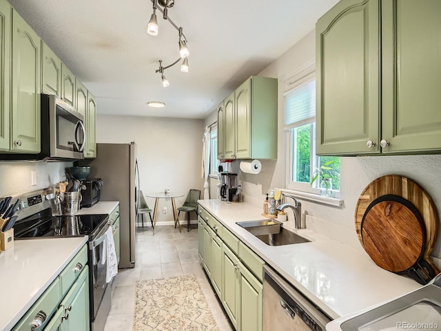 6346 Fenton St, Arvada, CO 80003 - kitchen with green cabinets, stainless steel appliances, a sink, and light countertops