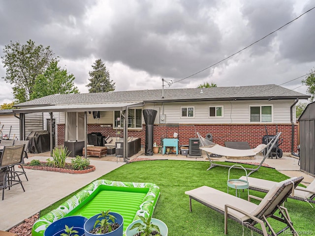 6346 Fenton St, Arvada, CO 80003 - back of house with brick siding, a patio, an outdoor living space, and a yard