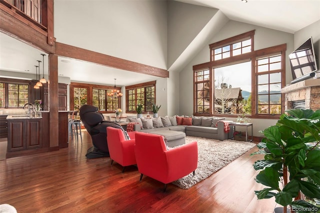 living room with dark wood-type flooring, a wealth of natural light, and an inviting chandelier