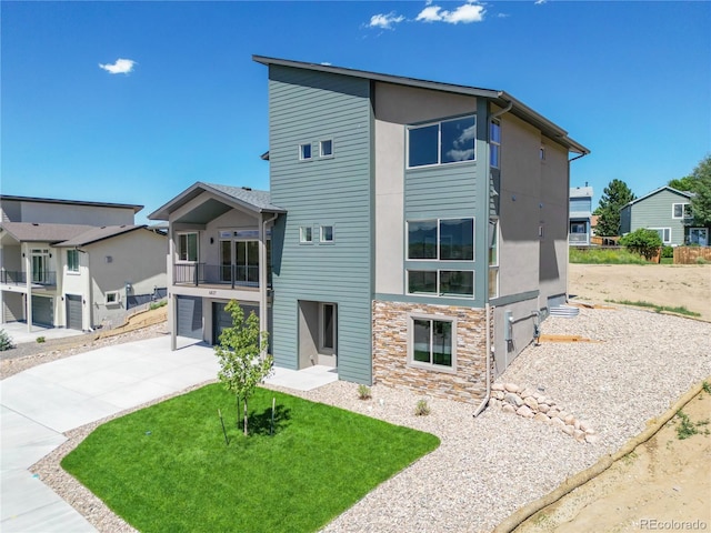 exterior space featuring a balcony, a lawn, and a garage