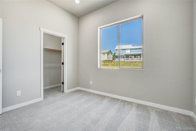 unfurnished bedroom featuring light carpet and a closet