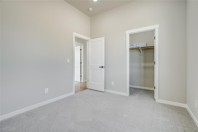 unfurnished bedroom with light colored carpet and a closet